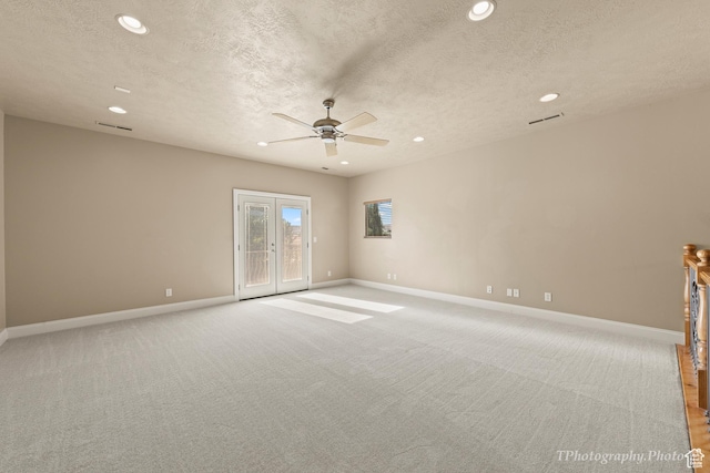 spare room with ceiling fan, light colored carpet, a textured ceiling, and french doors
