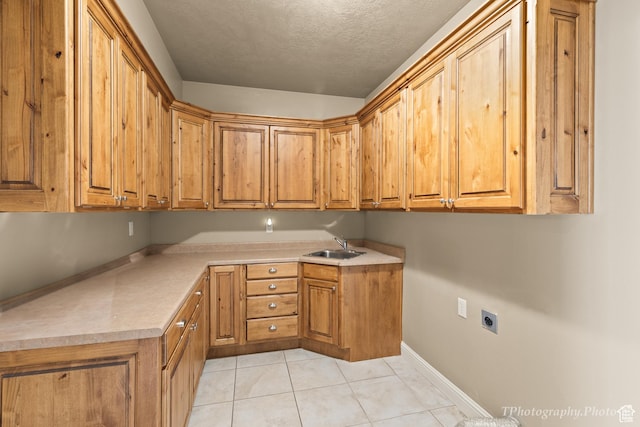 laundry room featuring sink, cabinets, light tile patterned floors, electric dryer hookup, and a textured ceiling