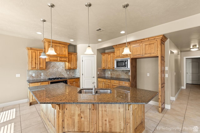 kitchen with sink, light tile patterned floors, a spacious island, tasteful backsplash, and built in microwave