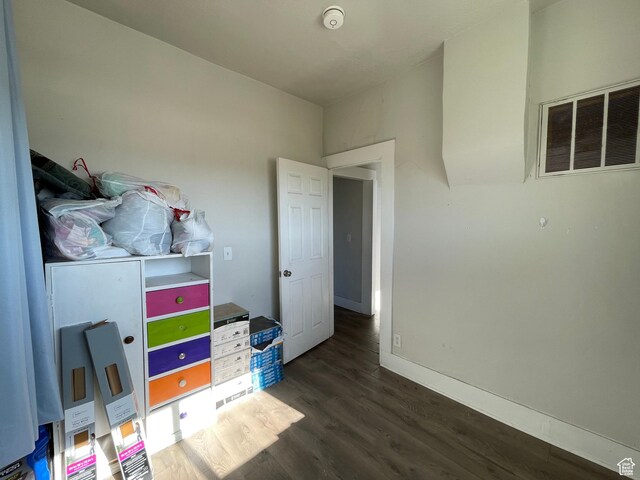 bedroom featuring dark wood-style flooring and baseboards