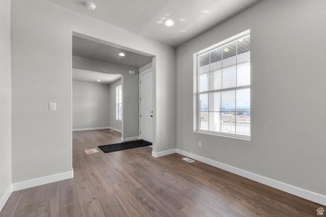 entrance foyer with a wealth of natural light, baseboards, and hardwood / wood-style flooring
