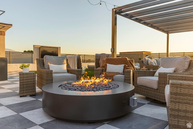 patio terrace at dusk featuring an outdoor fire pit