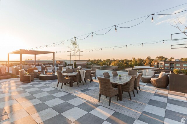 patio terrace at dusk featuring an outdoor living space with a fire pit