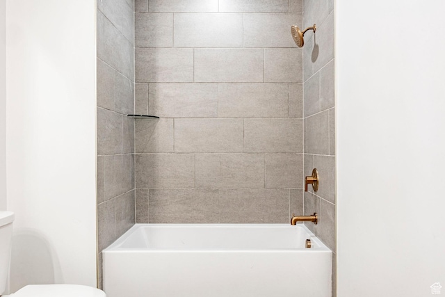 bathroom with tiled shower / bath and toilet