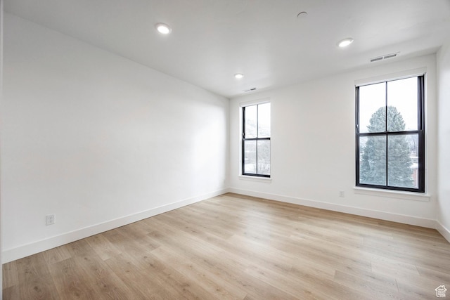 spare room with a wealth of natural light and light wood-type flooring