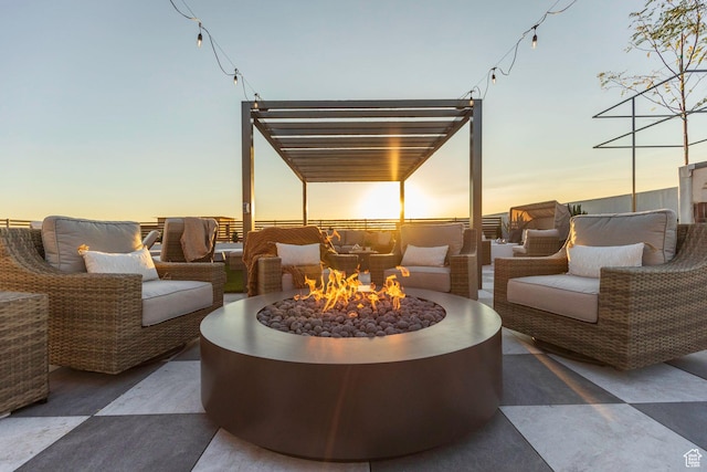 patio terrace at dusk with an outdoor living space with a fire pit