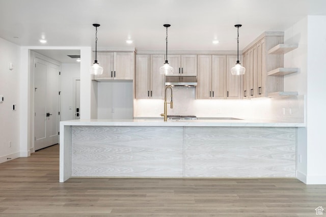 kitchen featuring sink, light hardwood / wood-style flooring, light brown cabinetry, and decorative light fixtures