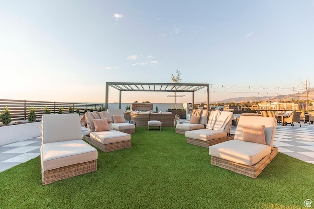 yard at dusk with outdoor lounge area, a pergola, and a patio area