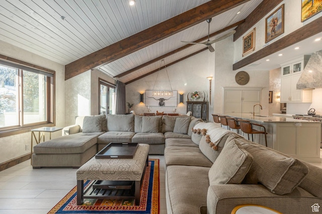 living area with plenty of natural light, high vaulted ceiling, beamed ceiling, and ceiling fan