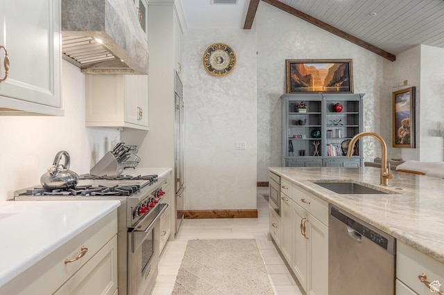 kitchen featuring a sink, lofted ceiling with beams, appliances with stainless steel finishes, custom exhaust hood, and white cabinets