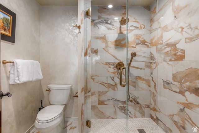 full bathroom featuring toilet and a marble finish shower