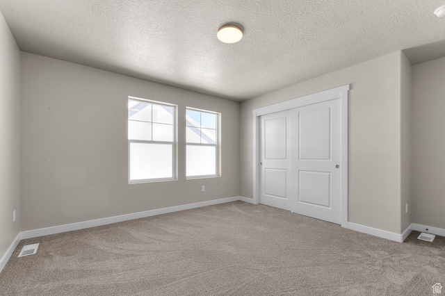 unfurnished bedroom with baseboards, visible vents, a closet, and carpet flooring