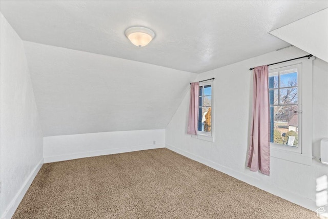 additional living space with lofted ceiling and carpet flooring