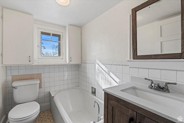 bathroom featuring a bathing tub, tile walls, vanity, and toilet