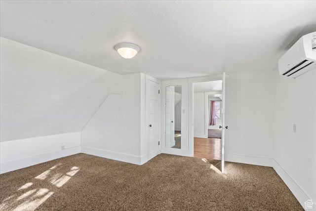 additional living space with lofted ceiling, carpet floors, a textured ceiling, and an AC wall unit