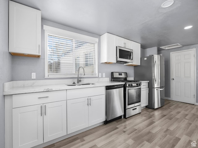 320 W Washington Ave S, American Fork, UT 84003 - kitchen featuring sink, stainless steel appliances, light stone countertops, light hardwood / wood-style floors, and white cabinets