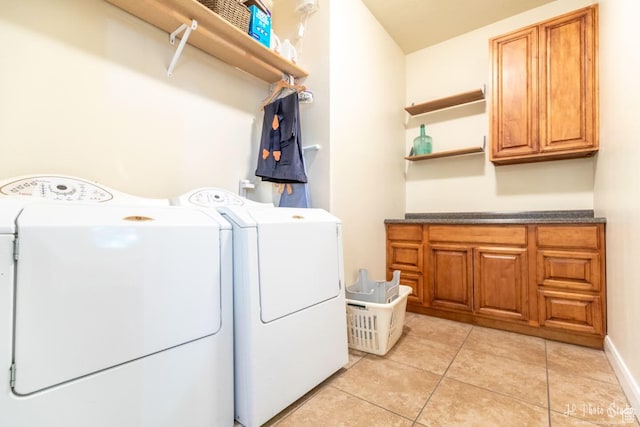 washroom with independent washer and dryer, light tile patterned floors, and cabinets