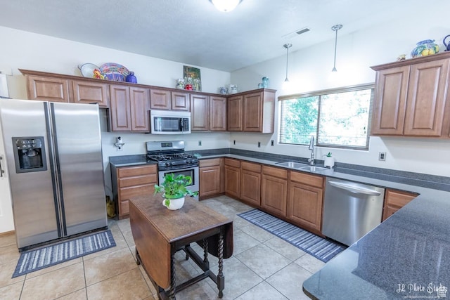 kitchen featuring pendant lighting, appliances with stainless steel finishes, sink, and light tile patterned floors