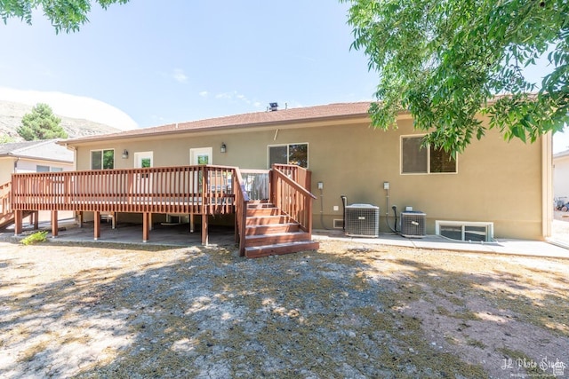back of house with a wooden deck and central AC