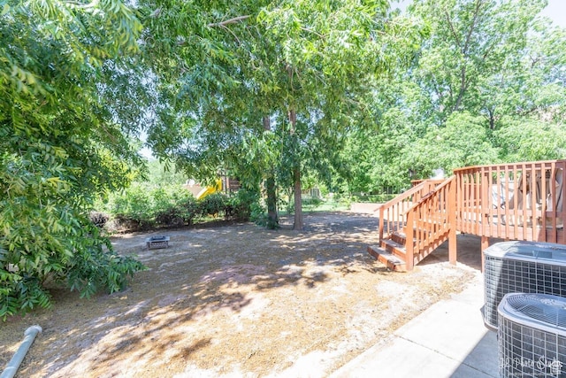 view of yard featuring a wooden deck and cooling unit