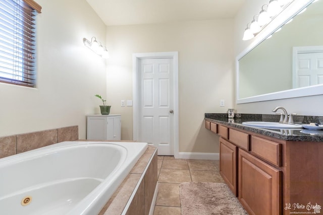 bathroom with tile patterned floors, vanity, and tiled tub