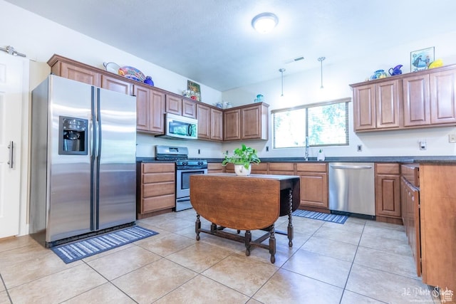 kitchen featuring stainless steel appliances, sink, and light tile patterned floors