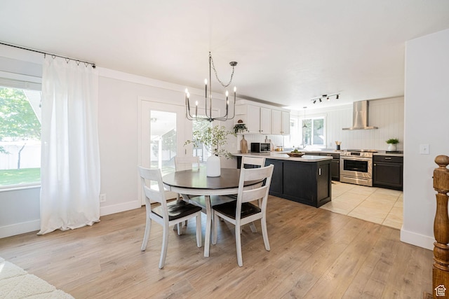 12138 S Willmar Cir, Riverton, UT 84065 - dining area with light wood finished floors, a chandelier, and track lighting