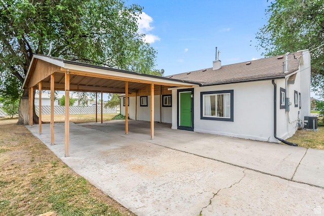 view of front of house with central AC unit and a carport