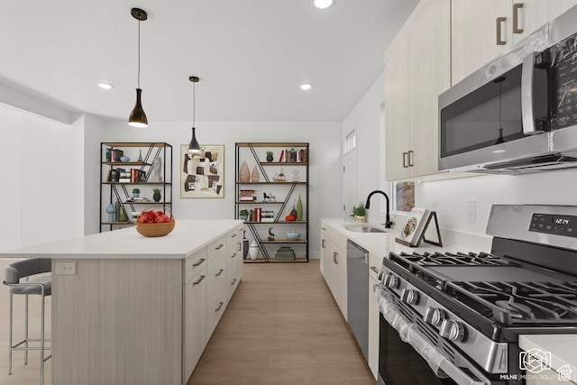 665 E 2015 N Unit 5C, Cedar City, UT 84721 - kitchen with sink, light hardwood / wood-style flooring, appliances with stainless steel finishes, a kitchen bar, and decorative light fixtures