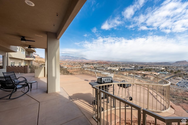 exterior space with a balcony, a mountain view, and ceiling fan