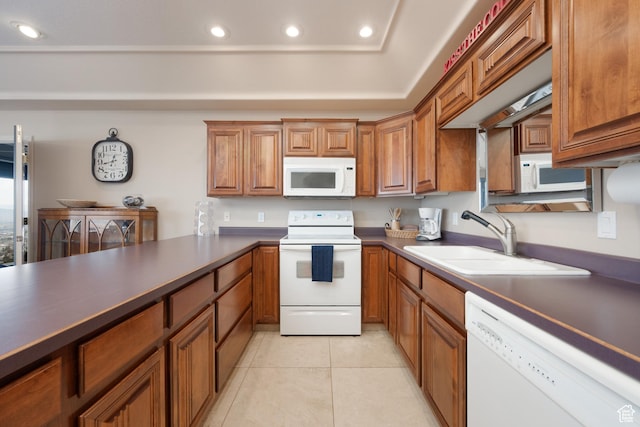 kitchen featuring light tile patterned flooring, white appliances, and sink