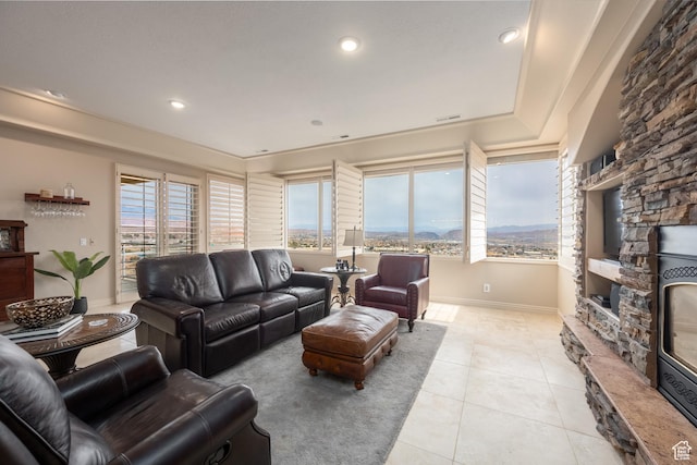 tiled living room with a stone fireplace and a wealth of natural light