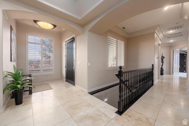 hallway featuring crown molding and light tile patterned floors