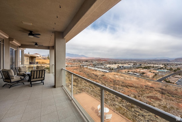 balcony featuring a mountain view and ceiling fan