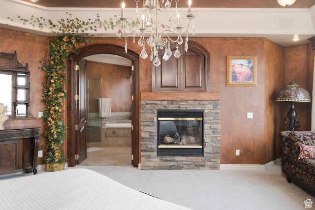bedroom featuring ensuite bathroom, a fireplace, a chandelier, and carpet floors