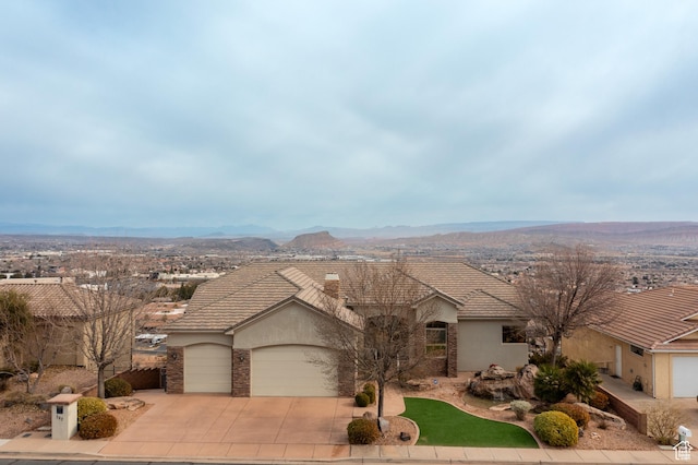 ranch-style home featuring a garage and a mountain view