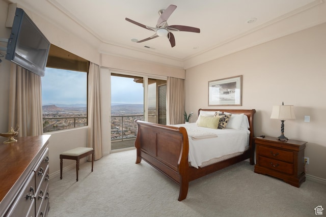 carpeted bedroom featuring ornamental molding, a mountain view, access to exterior, and ceiling fan
