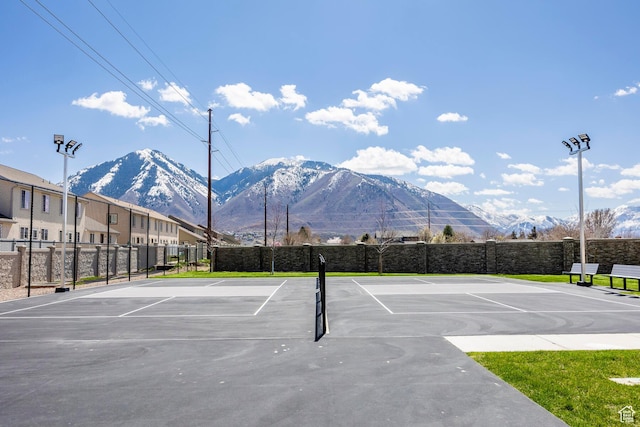 view of sport court featuring a mountain view and basketball hoop