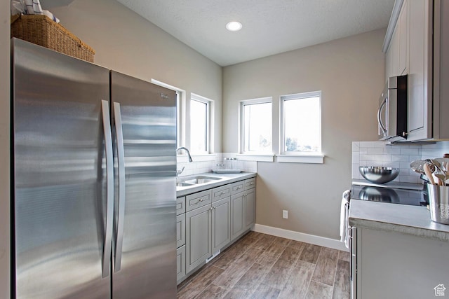 kitchen featuring gray cabinetry, sink, tasteful backsplash, and appliances with stainless steel finishes