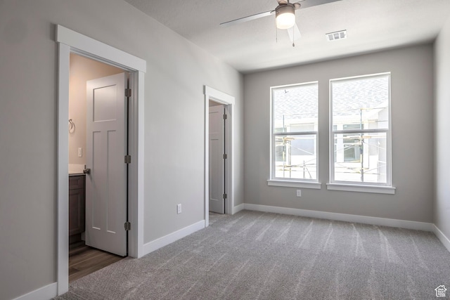 unfurnished bedroom featuring ceiling fan, ensuite bath, and carpet floors