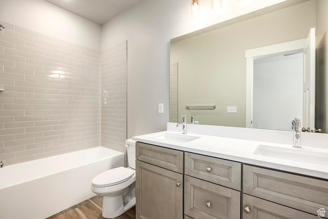 full bathroom with vanity, hardwood / wood-style flooring, tiled shower / bath combo, and toilet