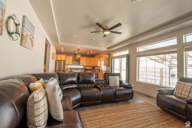 324 S Hayes Well Ln, Saratoga Springs, UT 84045 - living room with a raised ceiling, wood finished floors, a textured ceiling, baseboards, and ceiling fan