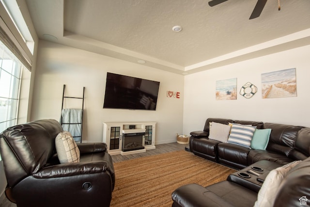 324 S Hayes Well Ln, Saratoga Springs, UT 84045 - living area featuring baseboards, a fireplace, ceiling fan, wood finished floors, and a raised ceiling