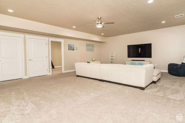 carpeted living room with ceiling fan and a textured ceiling