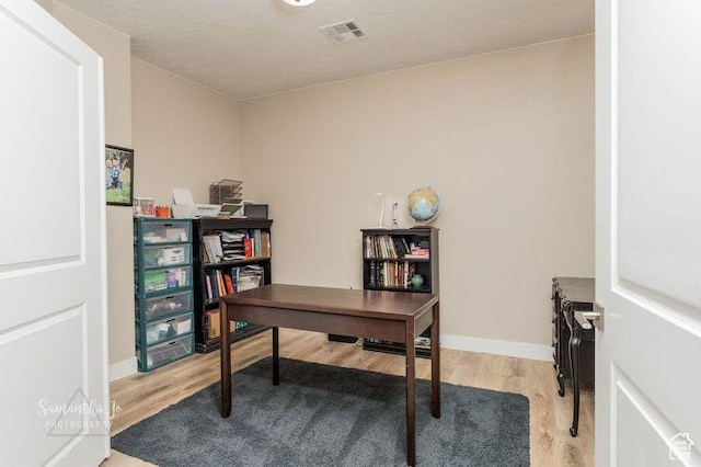 home office with light hardwood / wood-style floors
