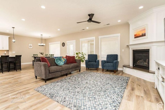 living room featuring ceiling fan and light hardwood / wood-style floors