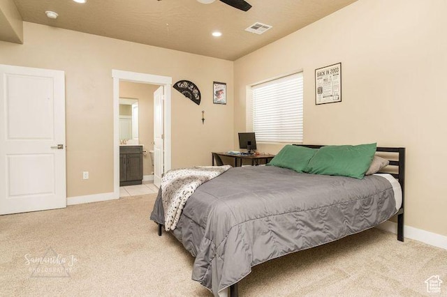 bedroom featuring ensuite bathroom and light carpet