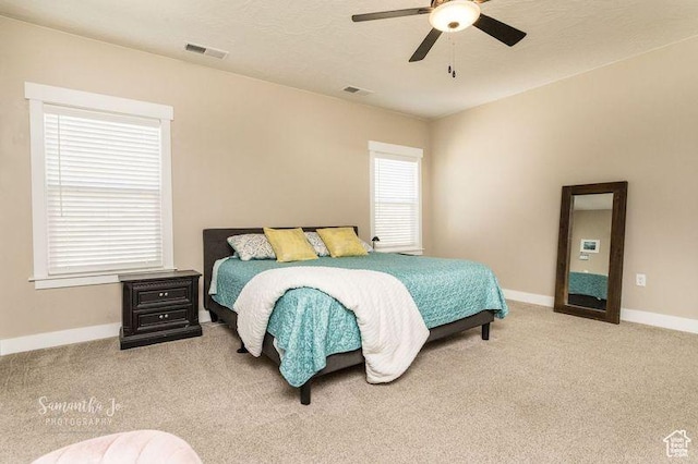 carpeted bedroom with a textured ceiling and ceiling fan