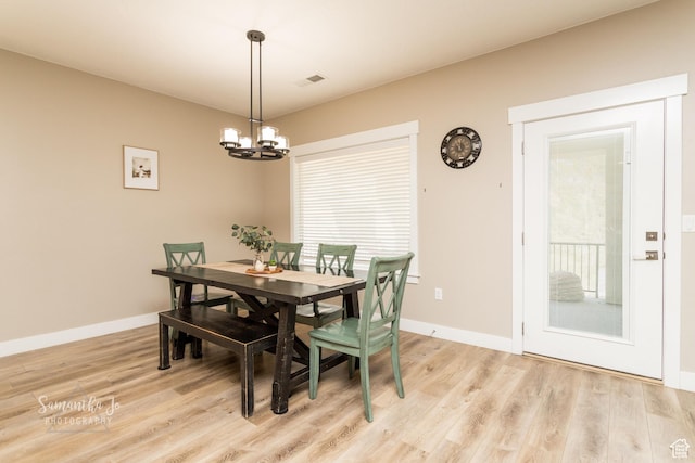 dining area featuring an inviting chandelier, a healthy amount of sunlight, and light hardwood / wood-style floors