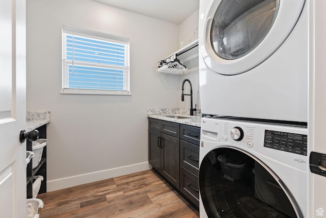 6007 W 8000 S, Payson, UT 84651 - clothes washing area with cabinet space, baseboards, wood finished floors, stacked washing maching and dryer, and a sink